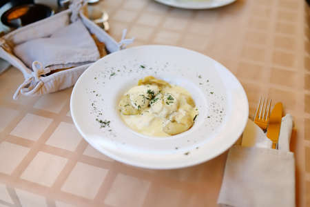 Traditional Lithuanian koldunai, small dumplings that come with a variety of fillings, server with sour cream. National Lithuanian cuisine.の写真素材