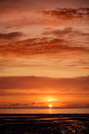 Beautiful sunset colors over the coastline of Allerdale district in Cumbria, UK. Sun setting over the shore of Allonby bay on autumn evening.の写真素材