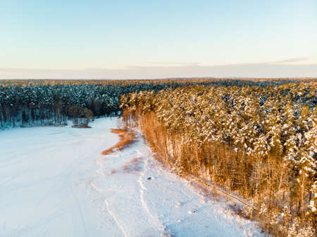 Beautiful aerial view of snow covered pine forests aroung Gela lake. Rime ice and hoar frost covering trees. Scenic winter landscape near Vilnius, Lithuania.の写真素材