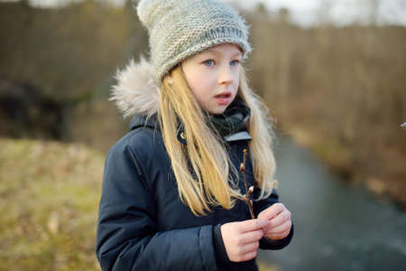 Cute young girl having fun during forest hike on beautiful winter day. Active family leisure with kids. Family fun.の写真素材