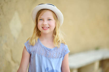 Cute young tourist girl exploring Sorano, an ancient medieval hill town hanging from a tuff stone...