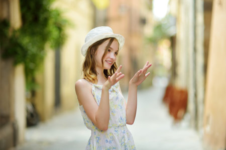 Young girl exploring medieval streets of picturesque resort town Bolsena, situated on the shores of Italy's largest lake, Lago Bolsena, in Lazio, Italy.の写真素材
