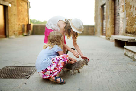 Young girls exploring the famous Pitigliano town, located atop a volcanic tufa ridge, known as the little Jerusalem. Beautiful italian towns and villages. Etruscan heritage, Grosseto, Tuscany, Italy.の写真素材