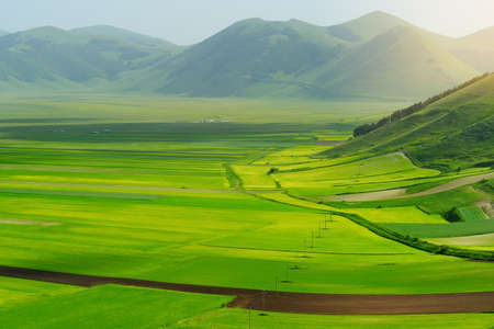 Piano Grande, large karstic plateau of Monti Sibillini mountains and one of the greatest tourist attractions in the area. Beautiful green fields of the Monti Sibillini National Park, Umbria, Italy.の写真素材
