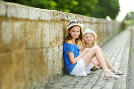 Two sisters exploring the famous Orvieto, a medieval hill town, rising above the almost-vertical faces of tuff cliffs and surrounded by its vineyards and wineries in Umbria, Italy.の写真素材