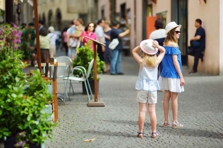 Two sisters exploring the famous Orvieto, a medieval hill town, rising above the almost-vertical faces of tuff cliffs and surrounded by its vineyards and wineries in Umbria, Italy.の写真素材