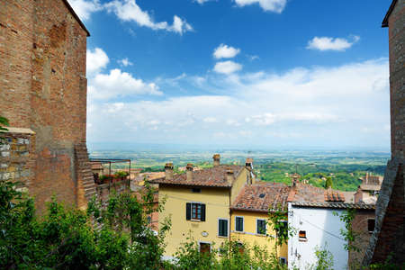 Green hills and pastures of Tuscany and rooftops of Montepulciano town, located on top of a limestone ridge surrounded by vineyards. Vino Nobile wine territory. Tuscany, Italy.の写真素材