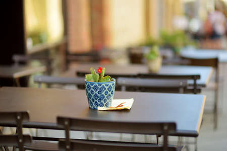 Empty restaurant table in medieval street of Montalcino town, located on top of a hill top and surrounded by vineyards, known worldwide for the production of delicious wine. Tuscany, Italy.の写真素材
