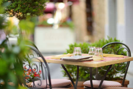 Empty restaurant table in medieval street of Montalcino town, located on top of a hill top and...