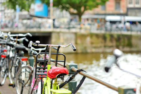 Bicycles parked on the bridge over canal in Amsterdam, Netherlands. Typical dutch city view in Holland.の写真素材