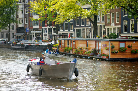 AMSTERDAM - AUGUST 2011: Famous canals of Amsterdam, Netherlands. Cars and bicycles parked on the embankments. Typical street view in Amsterdam, Holland.のeditorial素材
