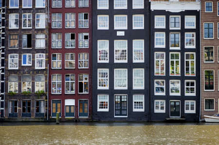 Evening view of the 'Dancing Houses of Damrak', iconic canal houses in the capital city of...