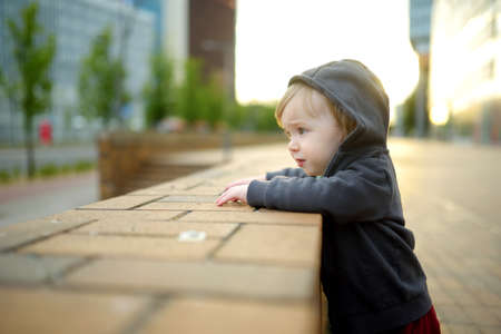 Funny toddler boy having fun in the city on sunny summer day. Outdoor summer activities for small kids.の写真素材