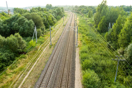 Beautiful top down aerial view of railroad tracks in the country. Railroad tracks surrounded by...