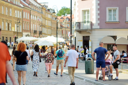 WARSAW, POLAND - AUGUST 2021: Tourists explore beautiful streets of the Old Town which was completely destroyed during the World War II and rebuilt in the years 1949-1953. Sunny summer day.のeditorial素材