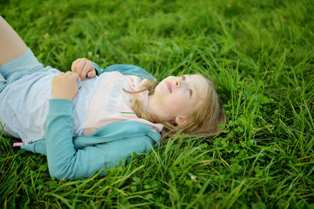 Cute young girl having fun outdoors on sunny summer day. Child exploring nature. High mountains and green hills in summer or spring. Scenic mountain view in Poland.の写真素材