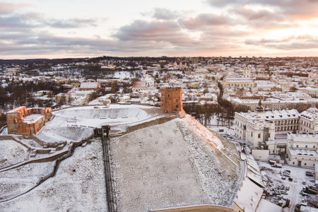 Aerial Vilnius city panorama in winter with snow covered houses, churches and streets. Gediminas tower in evening light. Winter city scenery in Vilnius, Lithuania.の写真素材