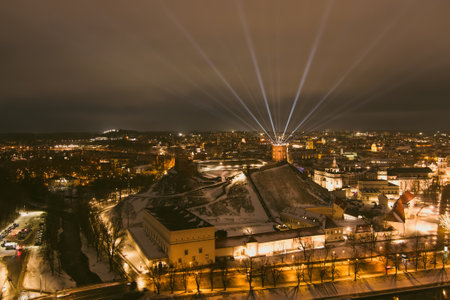 Scenic aerial view of Gediminas tower in Vilnius Old Town beautifully illuminated for 699th birthday celebration. Main symbol of Lithuanian capital at winter night.のeditorial素材