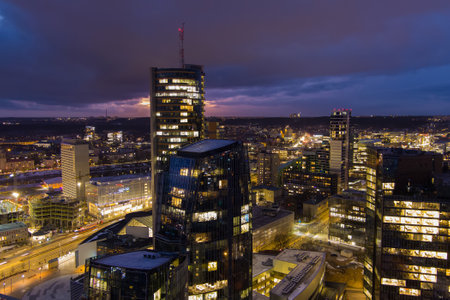 Beautiful aerial evening view of illuminated business district in Vilnius. Scenic winter sunset in capital of Lithuania.のeditorial素材