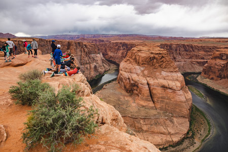 PAGE, ARIZONA, USA - APRIL 2016: Tourist at Horseshoe Bend lookout point on Colorado River in Glen Canyon, part of Grand canyon, Page, Arizona, USA. Exploring the American Southwest.のeditorial素材