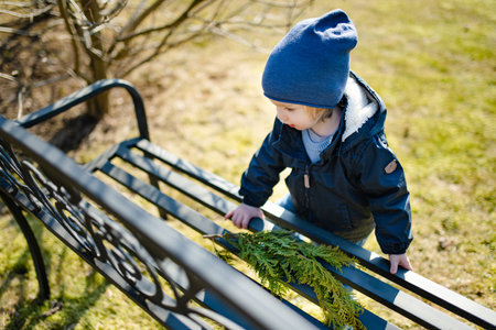 Cute toddler boy playing outdoors on sunny spring day. Child exploring nature. Early spring activities for small kids.の写真素材
