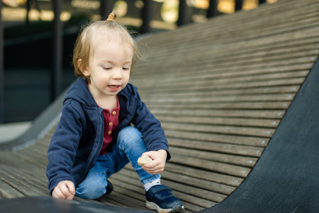Funny toddler boy having fun outdoors on sunny spring day. Child in the city. Kid playing in a city park. Active leisure for families with kids.の写真素材