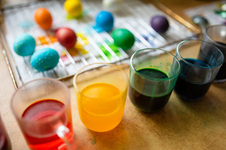 Using food coloring to dye Easter eggs at home. Painting colorful eggs for Easter hunt. Getting ready for Easter celebration. Family traditions.の写真素材