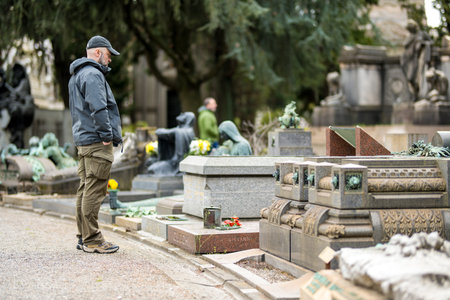 MILAN, ITALY - APRIL 2022: Male tourist admiring the impressive sculptures, tombs and monuments of Cimitero Monumentale di Milano or Monumental Cemetery of Milan. Milan, Italy.のeditorial素材