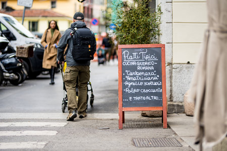 MILAN, ITALY - APRIL 2022: Outdoor restaurant menu on busy street in the center of Milan, a metropolis in Italy's northern Lombardy region. Milan, Lombardy, Italy.のeditorial素材