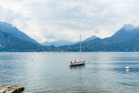 Small yacht docked in the marina of Varenna, one of the most picturesque towns on the shore of Lake Como. Varenna, Lombardy, Italy.の写真素材