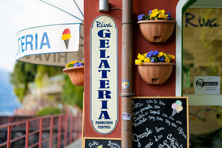 VARENNA, ITALY - APRIL 2022: Small gelateria serving assorted ice cream in Varenna, a town on the shore of Lake Como. Charming location with typical Italian atmosphere. Varenna, Lombardy, Italy.のeditorial素材