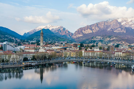 Cloudy aerial cityscape of Lecco town on spring evening. Picturesque waterfront of Lecco town located between famous Lake Como and scenic Bergamo Alps mountains. Vacation destination in Italy.の写真素材