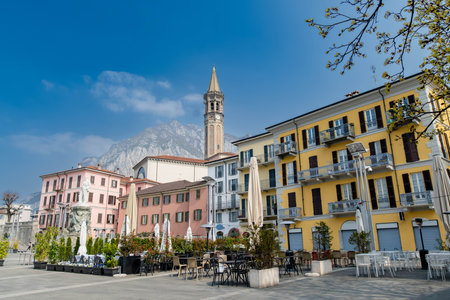 Mario Cermenati square of Lecco town, situated nearby to the memorial Monument of Mario Cermenati and the church Minor Basilica of San Nicolo. Sunny spring morning in Lecco, Lombardy, Italy.の写真素材