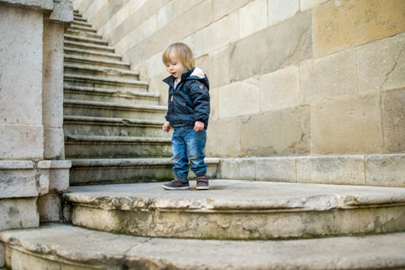 Cute toddler boy walking down the street of Bergamo. Little child having fun exploring in Citta Alta, upper district of Bergamo. Bergamo, Lombardy, Italy.の写真素材