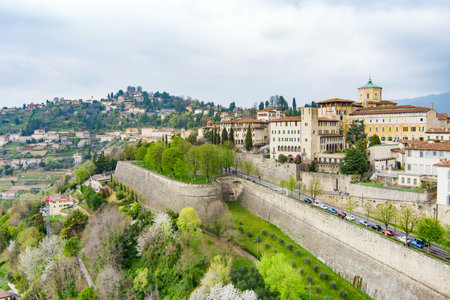 Scenic aerial view of Bergamo city northeast of Milan. Flying over Citta Alta, town's upper district, known by cobblestone streets and encircled by Venetian walls. Bergamo, Lombardy, Italy.の写真素材