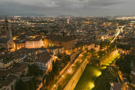 Scenic aerial view of Bergamo city northeast of Milan, on cloudy evening. Flying over Citta Alta, town's upper district encircled by Venetian walls. Bergamo, Lombardy, Italy.の写真素材