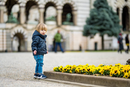 Little toddler boy visiting Cimitero Monumentale di Milano or Monumental Cemetery of Milan, one of the two largest cemeteries in Milan, noted for the abundance of artistic tombs and monuments.の写真素材