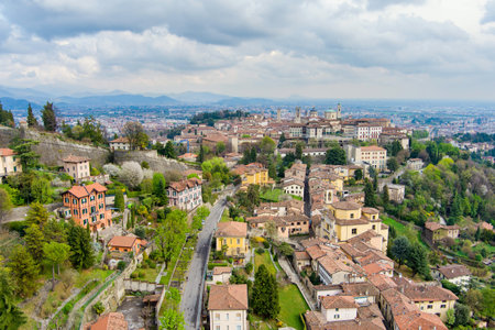 Scenic aerial view of Bergamo city northeast of Milan. Flying over Citta Alta, town's upper district, known by cobblestone streets and encircled by Venetian walls. Bergamo, Lombardy, Italy.の写真素材