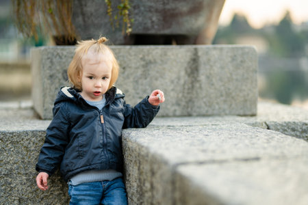 Cute toddler boy exploring in marina of Lecco town on spring day. Picturesque waterfront of Lecco located on the shore of Lake Como. Vacation destination in Italy.の写真素材