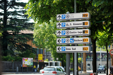 COMO, ITALY - MAY 2011: Road sign showing directions to the parking lots in Como, a town on the shore of Lake Como. Charming location with typical Italian atmosphere. Como, Lombardy, Italy.のeditorial素材