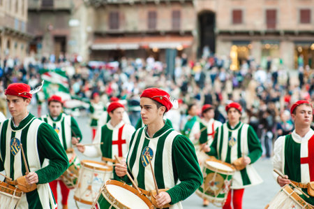 SIENA, ITALY - JULY 2013: Members of the noble Contrada dell'Oca carrying flags with a crowned goose on the Corteo Storico, a historical costume parade in Siena, Tuscany, Italy.のeditorial素材