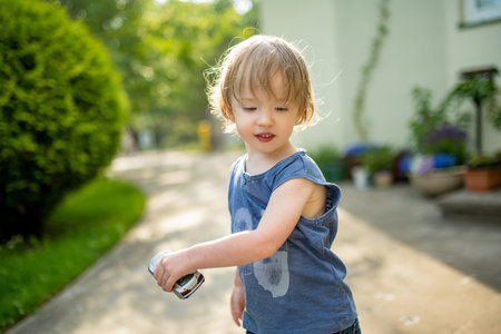 Adorable toddler boy having fun outdoors on sunny summer day. Child exploring nature. Summer...