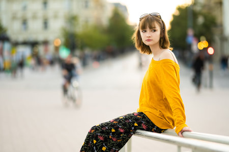 Cute teenage girl wearing yellow sweater exploring in Vilnius, Lithuania on warm and sunny summer day. Family leisure with kids.の写真素材