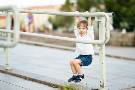 Funny toddler boy having fun in the city on sunny summer day. Outdoor summer activities for small kids.の写真素材