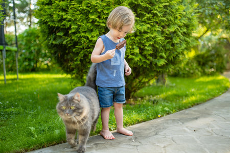 Cute toddler boy eating tasty fresh ice cream outdoors on warm sunny summer day. Children eating sweets. Unhealthy food for kids.の写真素材