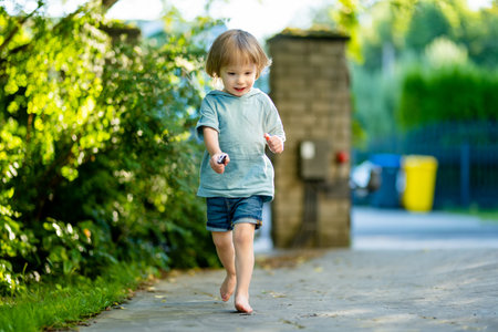 Adorable toddler boy having fun outdoors on sunny summer day. Child exploring nature. Summer activities for small kids.の写真素材