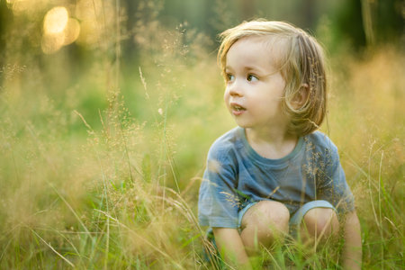 Adorable toddler boy having fun during a hike in the woods on beautiful sunny summer day. Active family leisure with kids. Child exploring nature.の写真素材