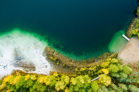Aerial view of beautiful green waters of lake Gela. Birds eye view of scenic emerald lake surrounded...