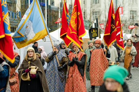 VILNIUS, LITHUANIA - MARCH 4, 2023: Cheerful people participating in humorous parade during Kaziuko muge or Kaziukas, traditional Easter market, crafts fair held every March on Old Town streets.のeditorial素材