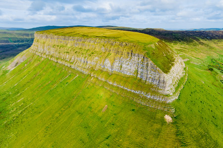 Aerial view of Benbulbin, aka Benbulben or Ben Bulben, iconic landmark, large flat-topped nunatak rock formation. Magnificent costal driving route view at Wild Atlantic Way, County Sligo, Ireland.の写真素材